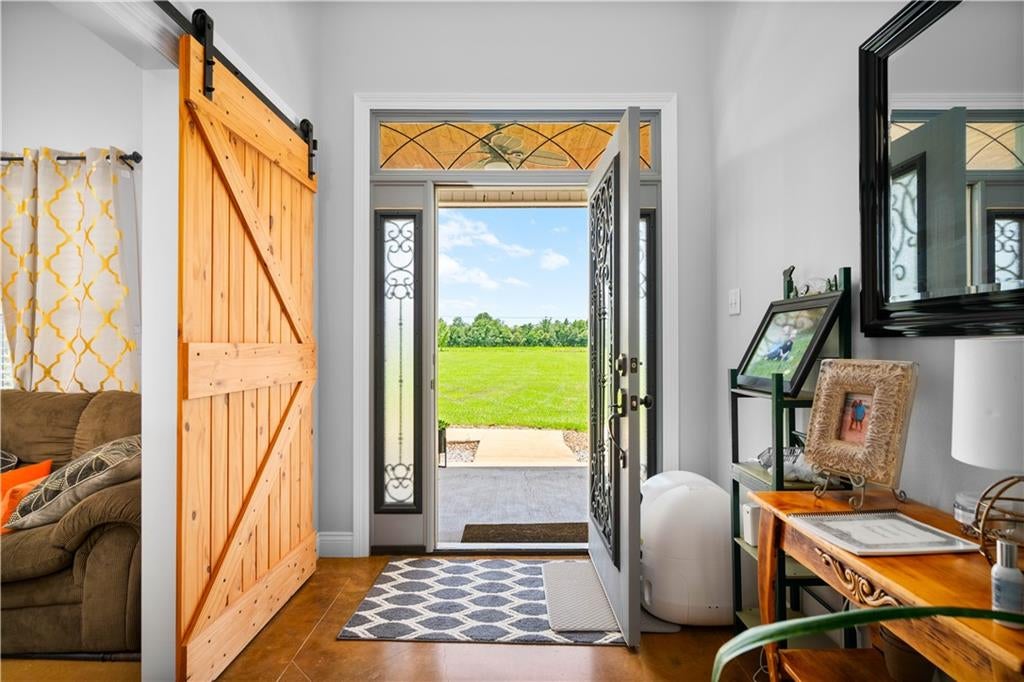 A welcoming entryway with a custom barn door, a cozy first-home detail